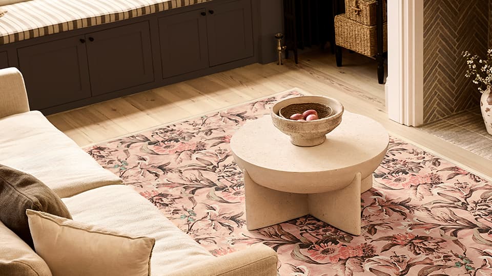 A neutral rug. There is a sofa and a coffee table.