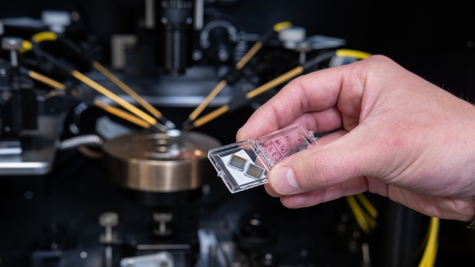 Electronic chips used to create artificial transneurons - tiny electronic circuits that replicate how brain cells pass signals between one another by generating small electrical pulses. They are pictured in front of the experimental setup used to capture how they responded to electrical input.