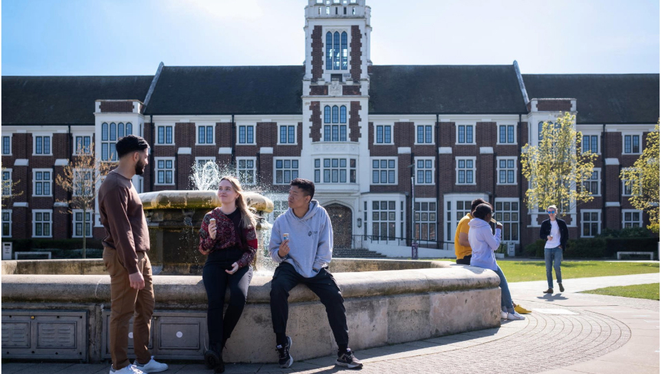 Three students sitting outside Hazlerigg