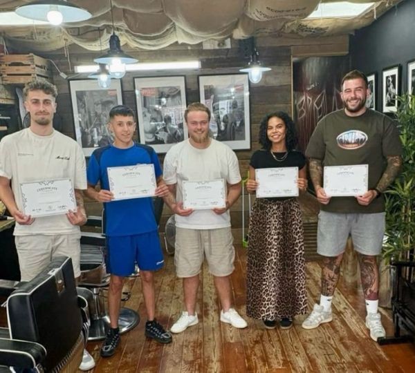 Bayley Greenaway presenting her Barbering Qualification