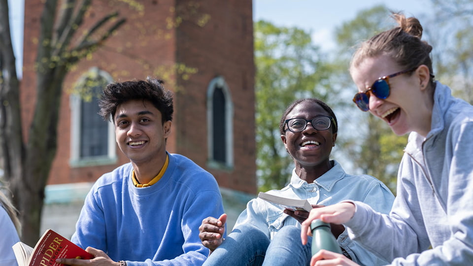 students sat in Queens Park in Loughborough town centre and laughing together in the sunny weather