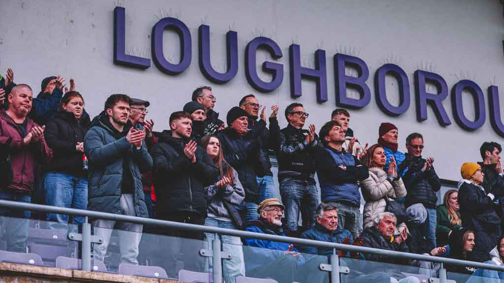 Spectators standing in the stands at the Loughborough University stadium
