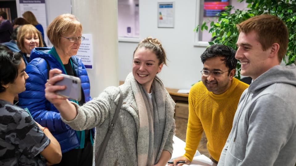 Alumnus Rahul Mandal having a photo taken with a group of people.