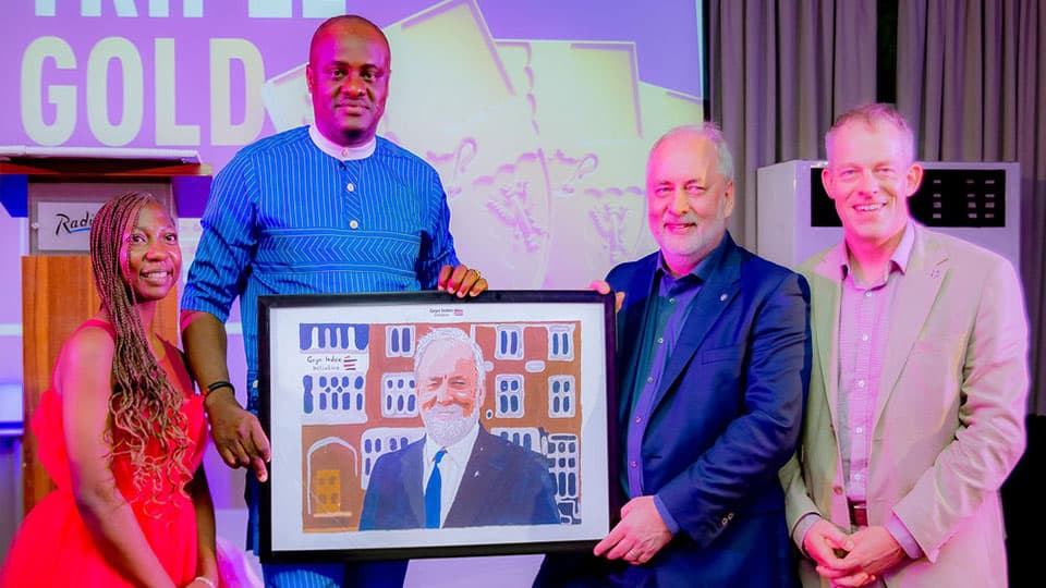 Professor Nick Jennings CB FREng FRS being presented with a gift/painting of himself at Loughborough University's reception in West Africa