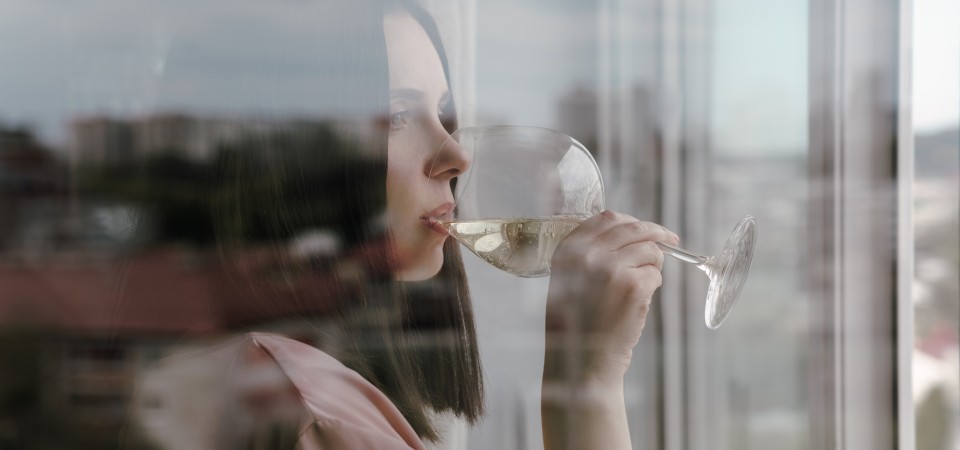 Girl drinking wine alone in her home