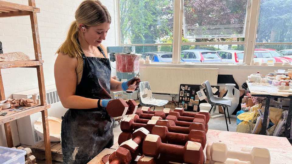 Ellie Robins making her ceramic dumbbells in an art studio.