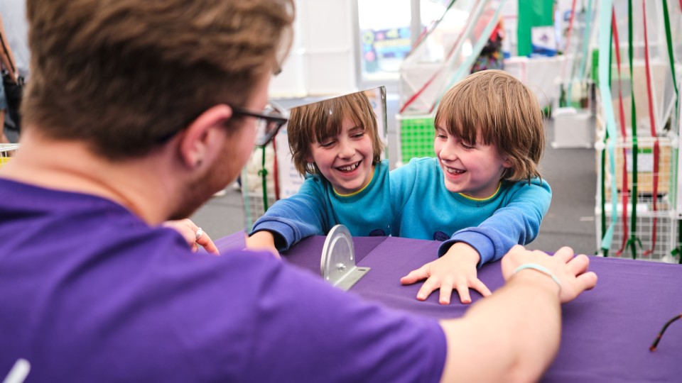 A child takes part in a mirror illusion