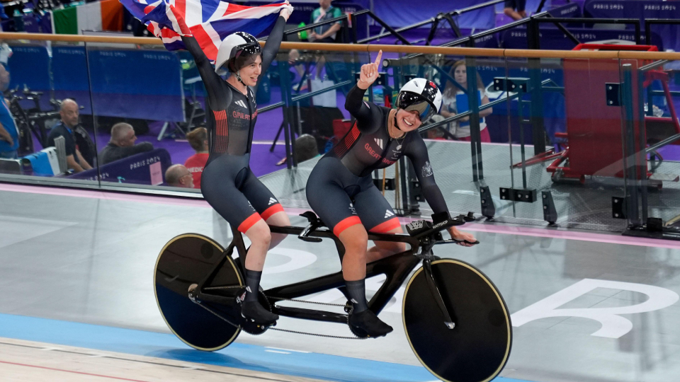 cyclist jenny holl on a bike celebrating a gold medal at the paralympic games