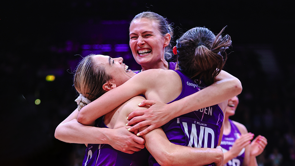 a group of female athletes celebrating in a huddle