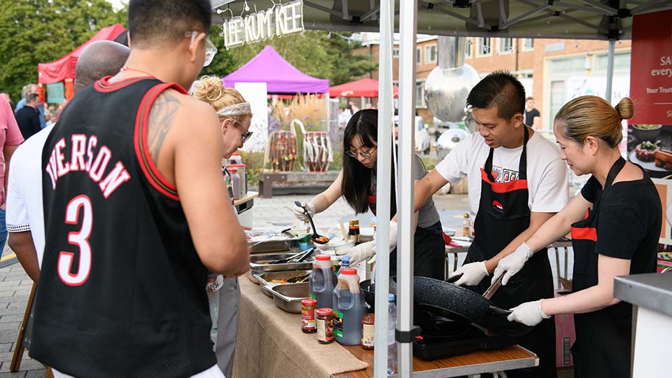 People serving food from a stand at the 2025 TUCO Summer Conference.