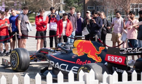 Red Bull F1 Race Car with students gathered around viewing the car