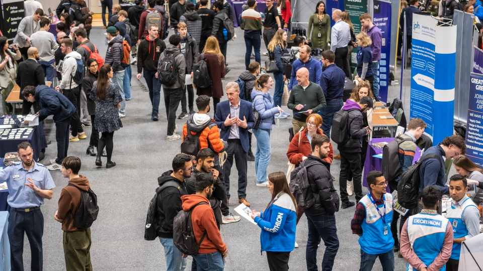 Lots of people standing and talking at the 2023 Spring Careers Fair.