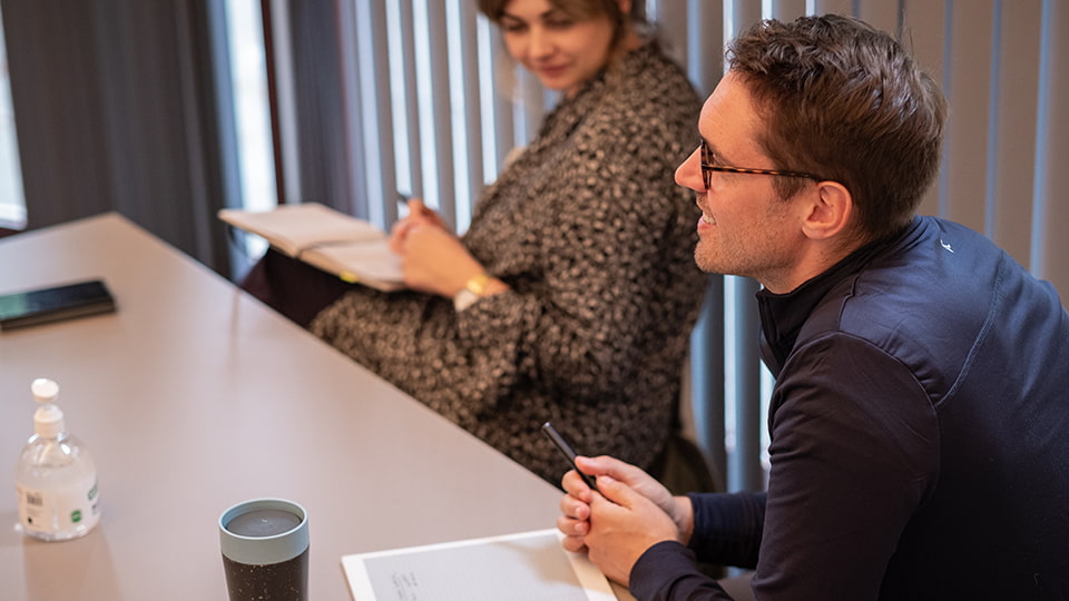 A man sitting an interview with a sheet of paper in front of him