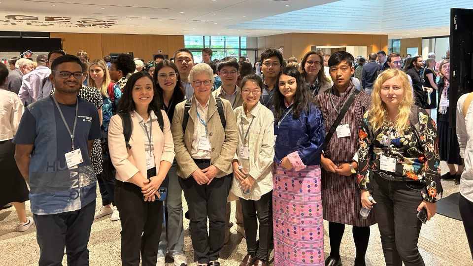 Young scientists standing with Prof. Anne L’Huillier.