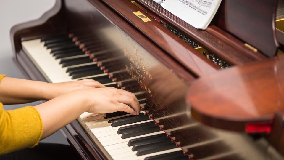 Close-up of a person playing a piano.