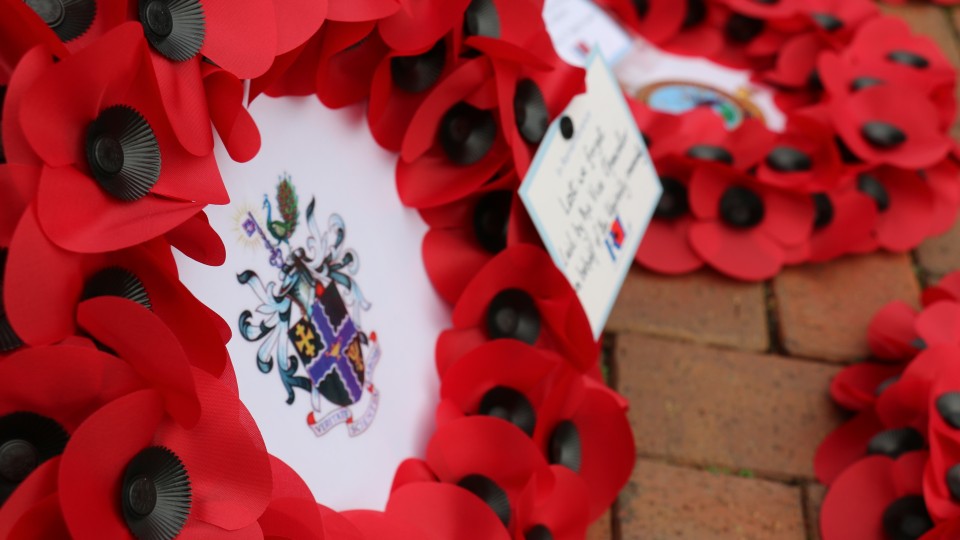 A wreath of poppies for a Remembrance Service, with the Loughborough University crest in the middle